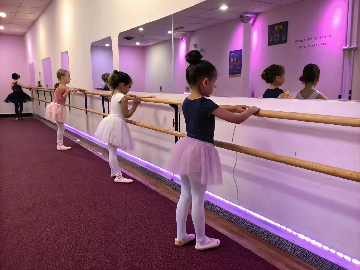 A vibrant image of young children in ballet class, practicing their poses with focused expressions, showcasing the beginner ballet program at ECOLE DE DANSE D’ARGENTAT.